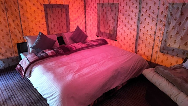 A room with a bed, a chair, and a window. - Himalayan Routes Camp (Lahul)