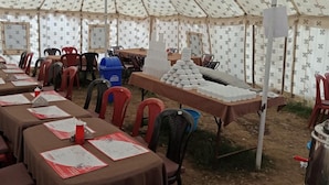A tented dining area with tables set for a meal, arranged in rows with chairs. - Himalayan Routes Camp (Lahul)