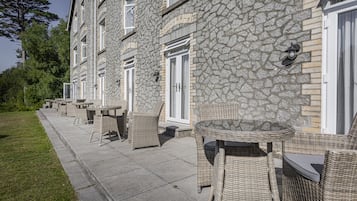 A stone building with outdoor seating and a paved walkway.