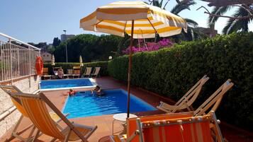 Kauden mukainen ulkouima-allas, aurinkovarjoja, aurinkotuoleja