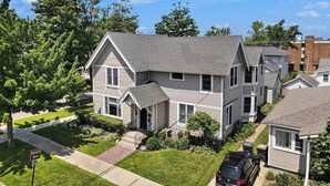 A two-story residential house with a front porch and a driveway.