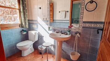 Un baño con inodoro, lavabo y espejo.