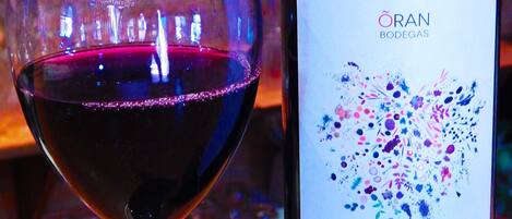 Una botella de vino Vina Roja junto a una copa llena del mismo vino.