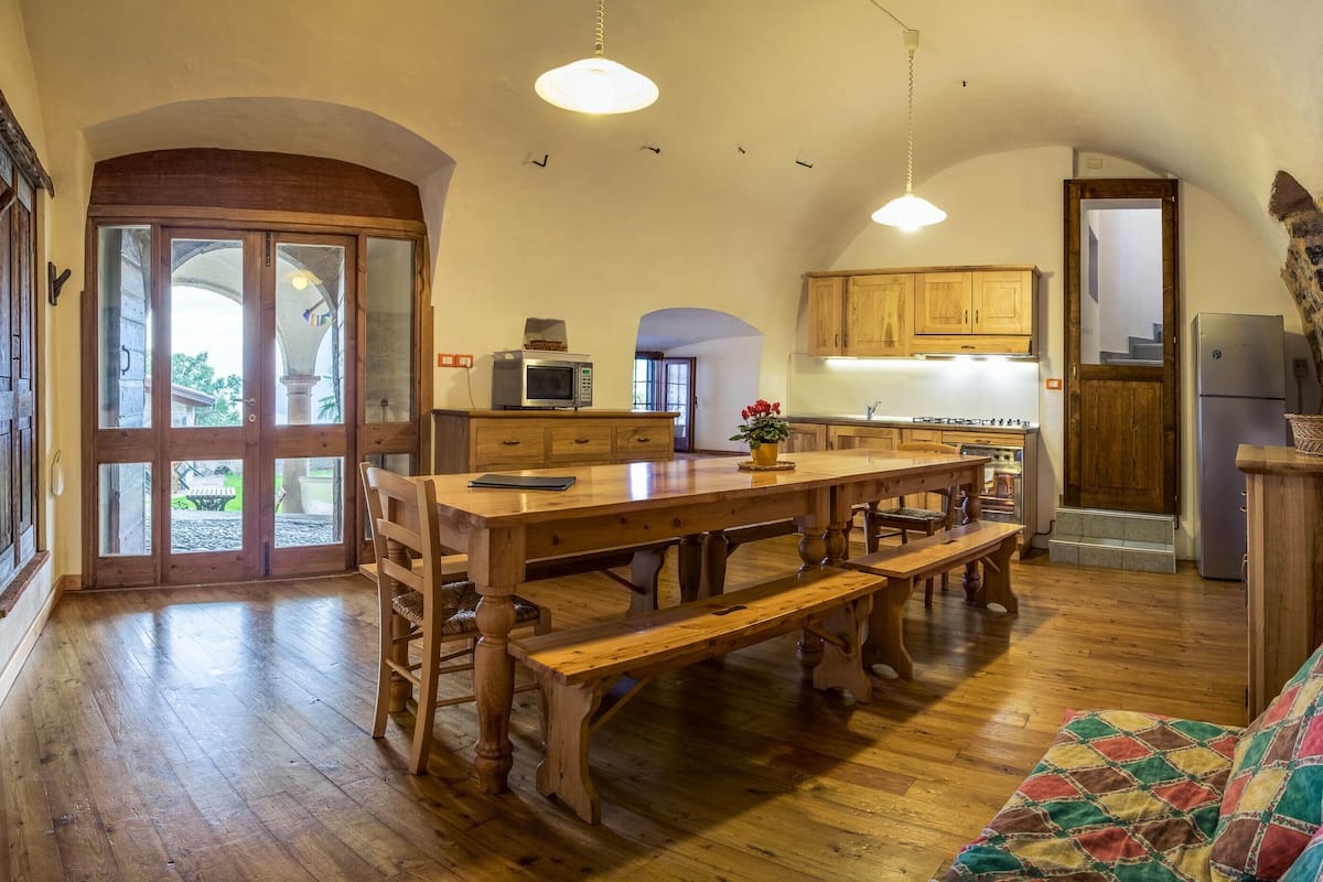 Una cocina amplia con muebles de madera, una isla grande y un comedor con bancos.