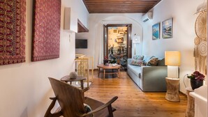 A cozy living room with a wooden floor, a sofa, a chair, and a lamp. - Casa Irene (Chania)