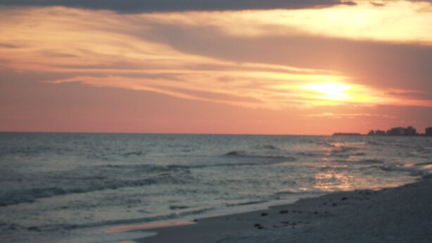 Ein Strand bei Sonnenuntergang über dem Meer.