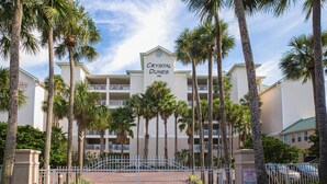 A hotel named Crystal Dunes with a white facade, multiple balconies, and palm trees in the foreground. - Stunning Beachfront Condo w/ Free Beach Service~ Crystal Dunes 405 (Destin)