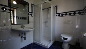 A bathroom with a glass-enclosed shower, a white sink, and a toilet. - Agriturismo Valdifiori (Sassoferrato)