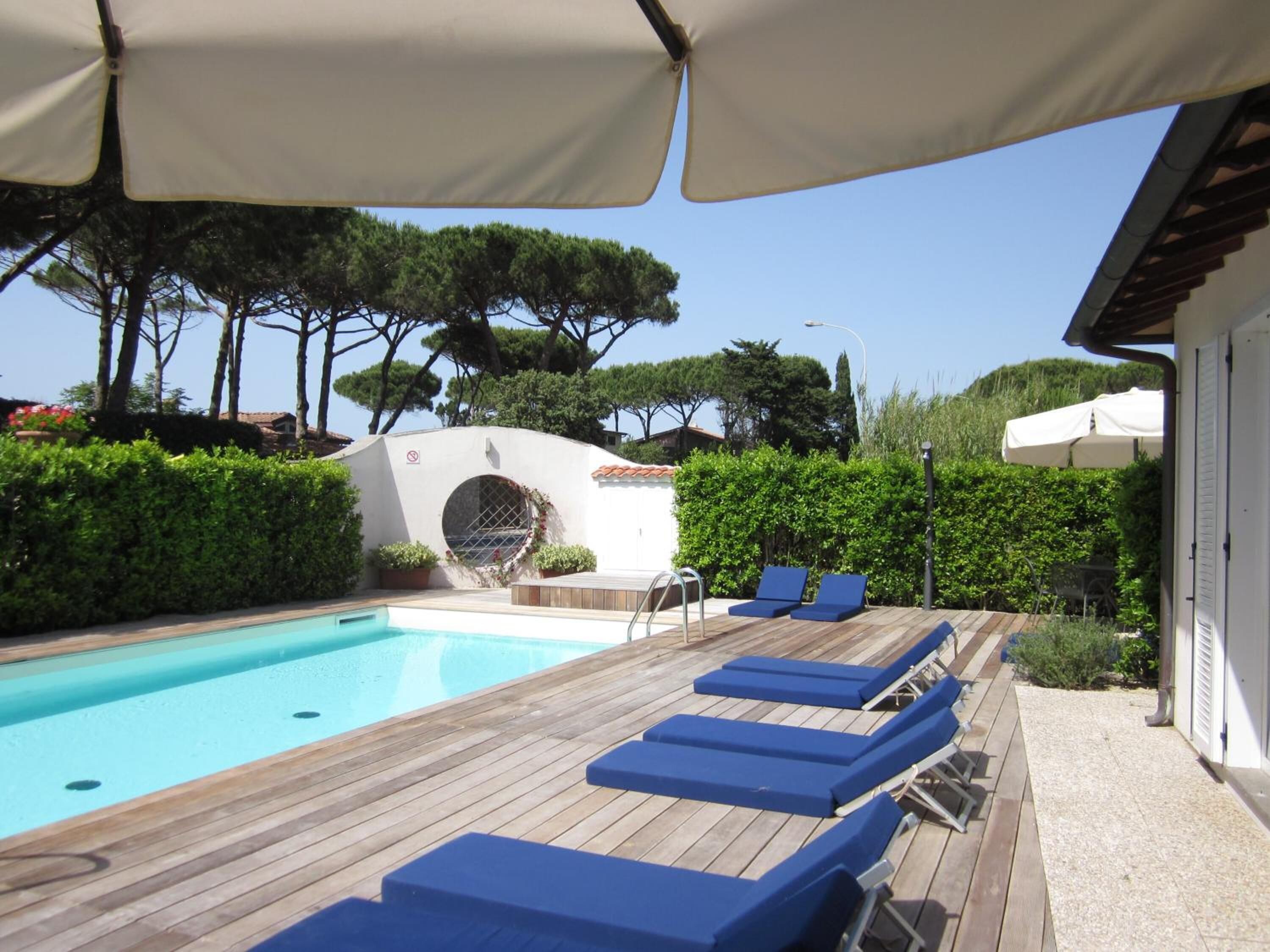 Una piscina al aire libre de temporada, sillones reclinables de piscina