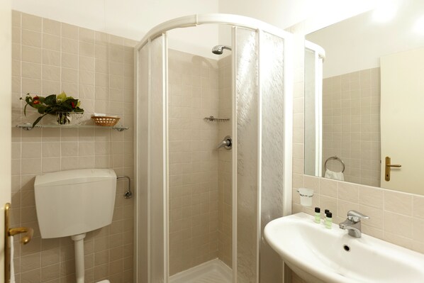 Un baño con inodoro, ducha y lavamanos.