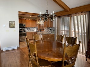 Enjoy meals in this dining area with a large table and six chairs, surrounded by a high ceiling and modern lighting.