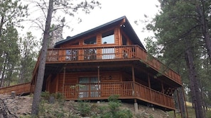 Relax on the upper-level balcony amidst the serene forest surroundings.