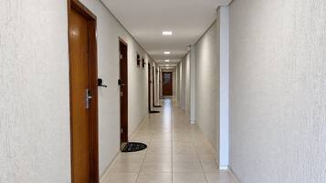 Un pasillo largo y estrecho con puertas a ambos lados, que conduce a habitaciones individuales.