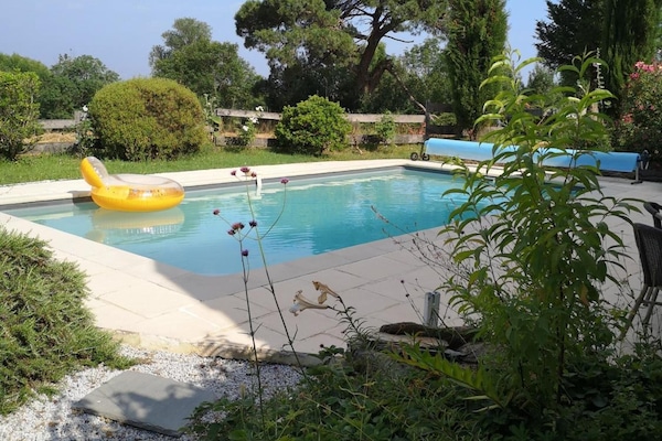 Una piscina al aire libre, sillones reclinables de piscina
