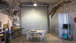 A kitchen with a round table, chairs, a stove, and various kitchen items.