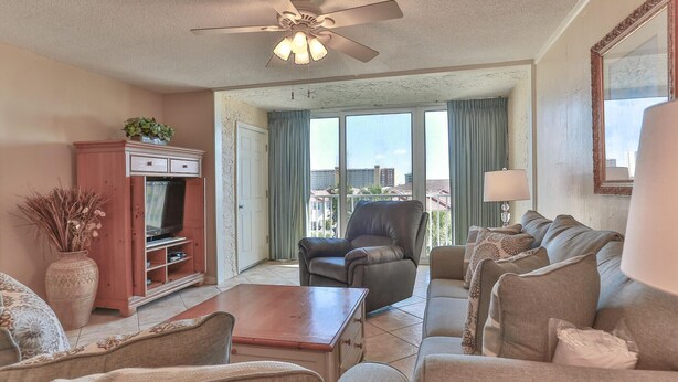 A living room with a television, a sofa, a chair, and a coffee table.