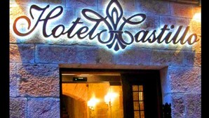 A hotel entrance with a stone facade and a sign reading "Hotel Castillo."
