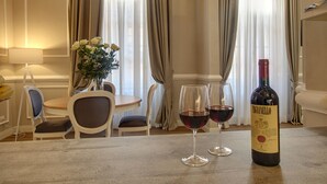 Ein Esstisch mit zwei Weingläsern und einer Weinflasche in einem Hotelzimmer.