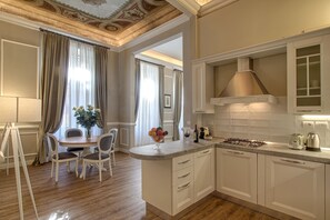 Une cuisine moderne avec des meubles blancs, une cuisinière à gaz et une machine à café.