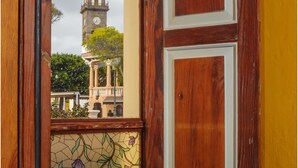 A wooden door with a stained glass window, a clock tower, and a balcony with a railing. - B&B Buenavista del Norte (Buenavista del Norte)