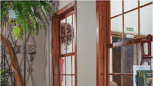 A room with a leather sofa, a staircase, a bookshelf, and a window with a view. - B&B Buenavista del Norte (Buenavista del Norte)