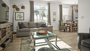 A living room with a sofa, coffee table, and dining area.
