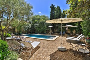 Ein Poolbereich mit Liegestühlen, Sonnenschirmen und einem Pool.