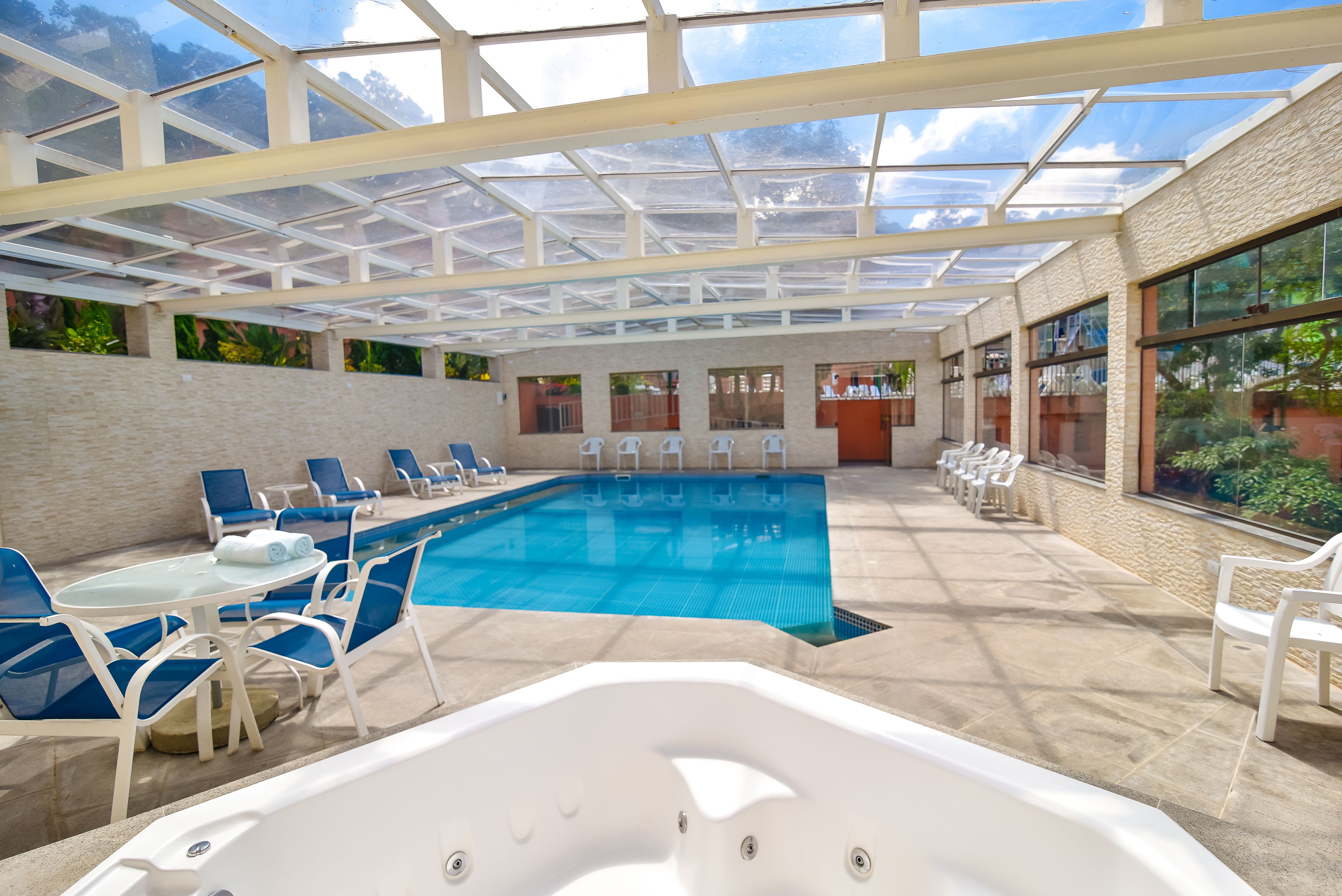 Una piscina interior con sillas de descanso y un jacuzzi.