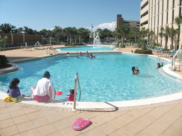 Relax by the pool surrounded by lounge chairs and umbrellas.