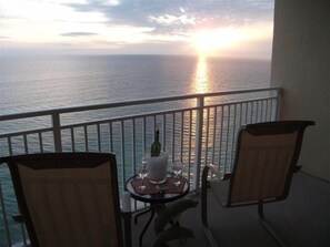 Enjoy the ocean view from this balcony with a table for two and comfortable seating.