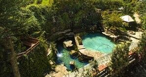 A circular pool surrounded by stone steps and lush greenery. - Cusco Villas Best Villa in Cusco (Lamay, Calca)