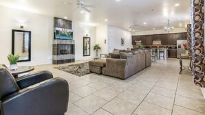 A spacious living area with a large sectional sofa, a flat-screen TV, and a fireplace. - 15% OFF Monthly |10% OFF Weekly-Carondelet Street Inviting Condos (New Orleans)