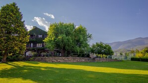 A large house with a stone wall and a lush green lawn. - Mas D'en Roqueta (Montferrer I Castellbo)