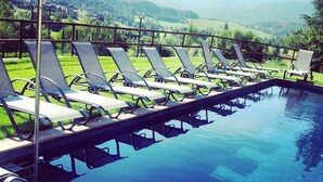 A poolside area with lounge chairs and a view of the countryside. - Mas D'en Roqueta (Montferrer I Castellbo)