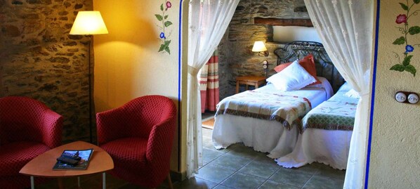 A cozy room with a bed, a red armchair, and a small table with a book. - Mas D'en Roqueta (Montferrer I Castellbo)