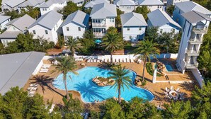 Un quartier résidentiel comprenant plusieurs maisons, une piscine et des palmiers.