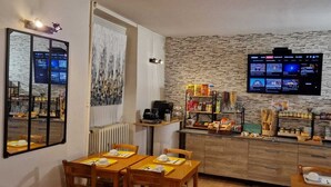 Una cocina moderna con una pared de piedra, un televisor de pantalla plana y un mostrador tipo buffet con diversas opciones de comida.