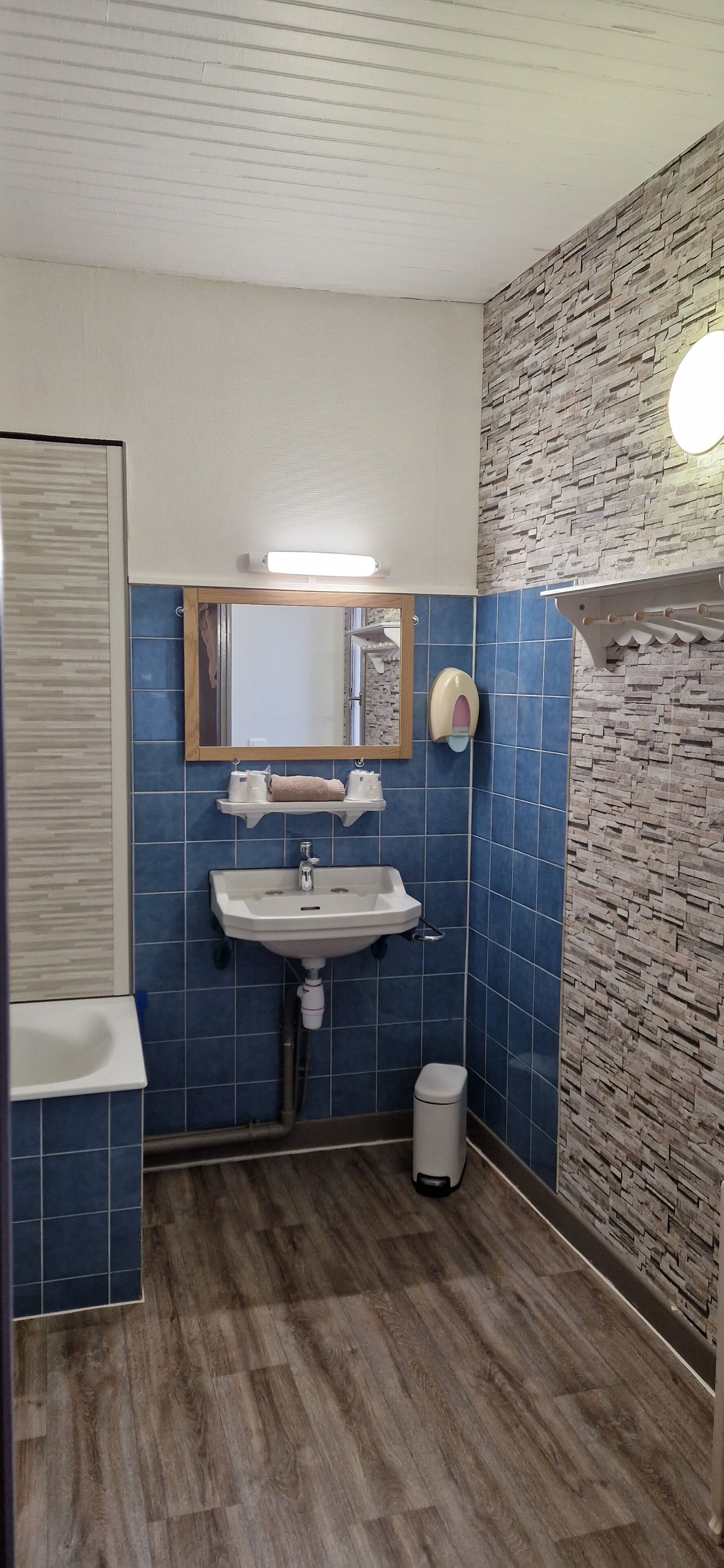Une salle de bain avec un lavabo, un miroir et des carreaux bleus.