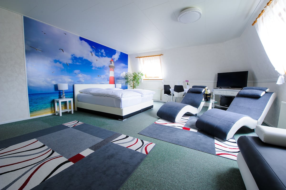 Une chambre d’hôtel avec un lit, une télévision, un bureau et une chaise.