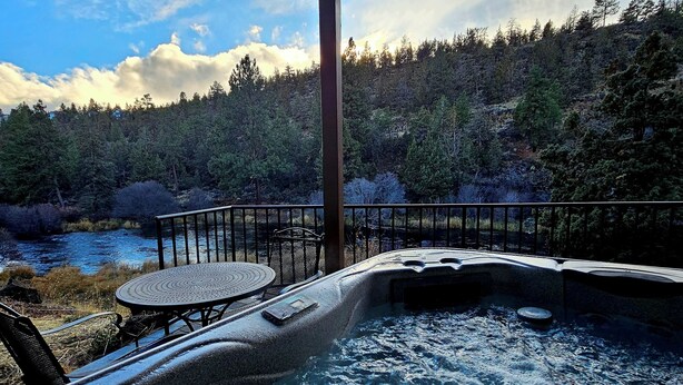 A hot tub area with a view of a forested hillside and a river. - Bend River Retreat (Bend)
