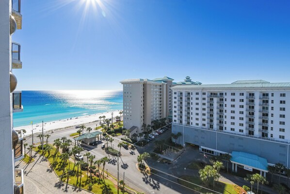 A hotel with a beachfront view, multiple floors, and a parking area with palm trees. - Contemporary cozy resort condo w/balcony & beach views! (Miramar Beach)