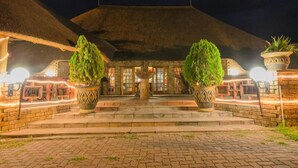 A building with a thatched roof, a central fountain, and potted plants. - Pepe Piatto (Dipaleseng)