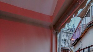 A balcony with a red railing, a white chair, and a table. - Chez Bore  (Istanbul)