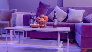 A modern living room with a sofa, a coffee table, and a basket of fruits and bottles. - Chez Bore  (Istanbul)