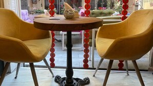 A dining area with a round table and two yellow chairs, decorated with red ornaments. - Chez Bore  (Istanbul)