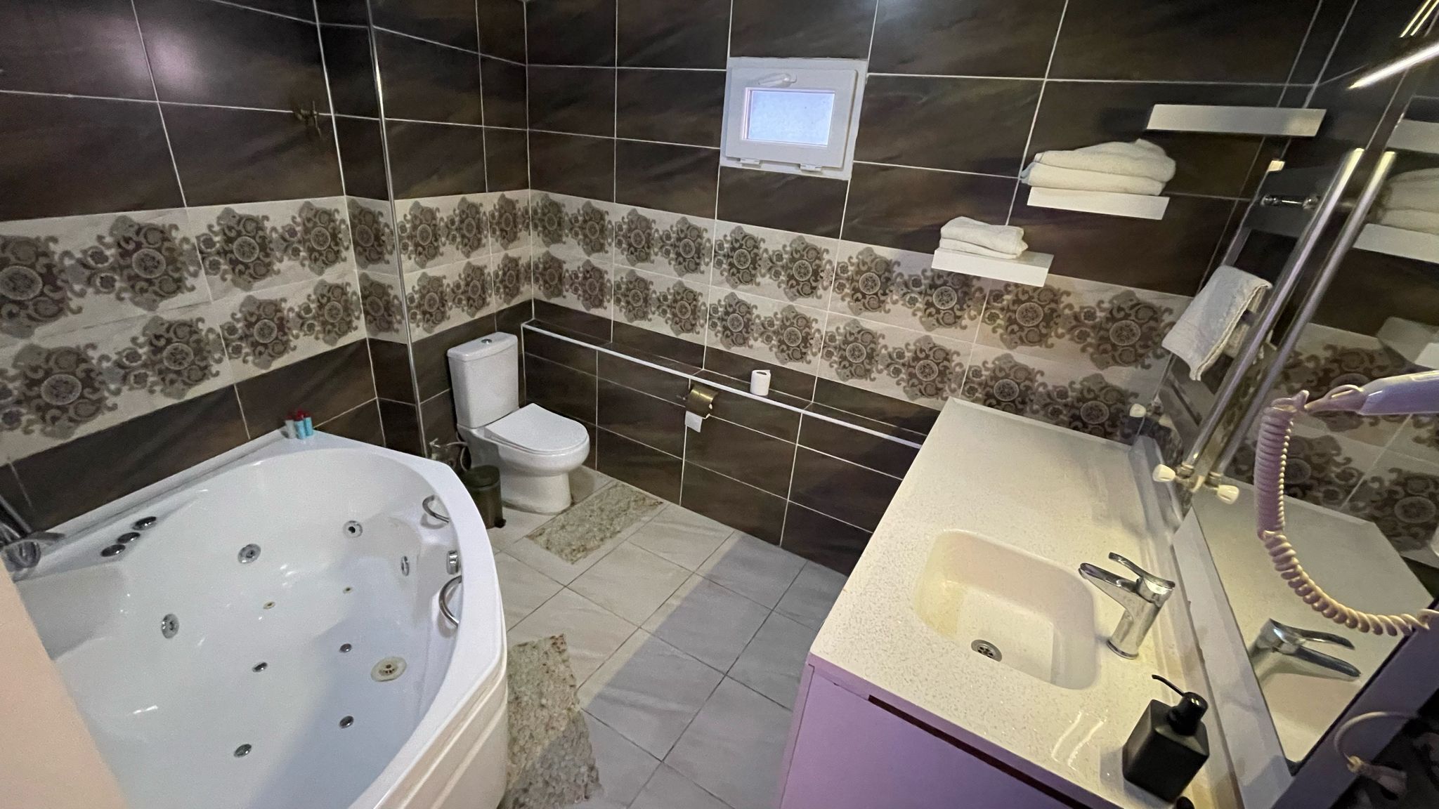 Casa de banho com banheira, sanita e lavatório.