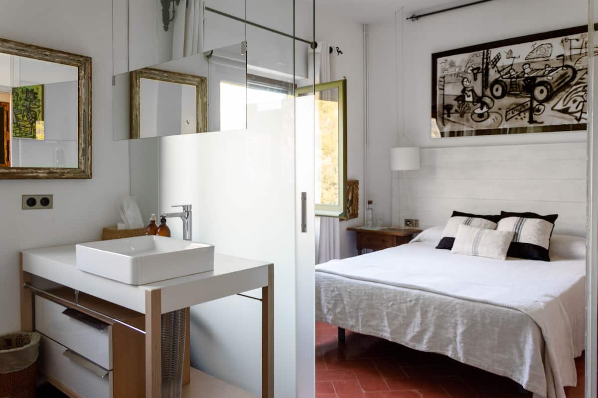 A modern bathroom with a large mirror, a white sink, and a shower area.