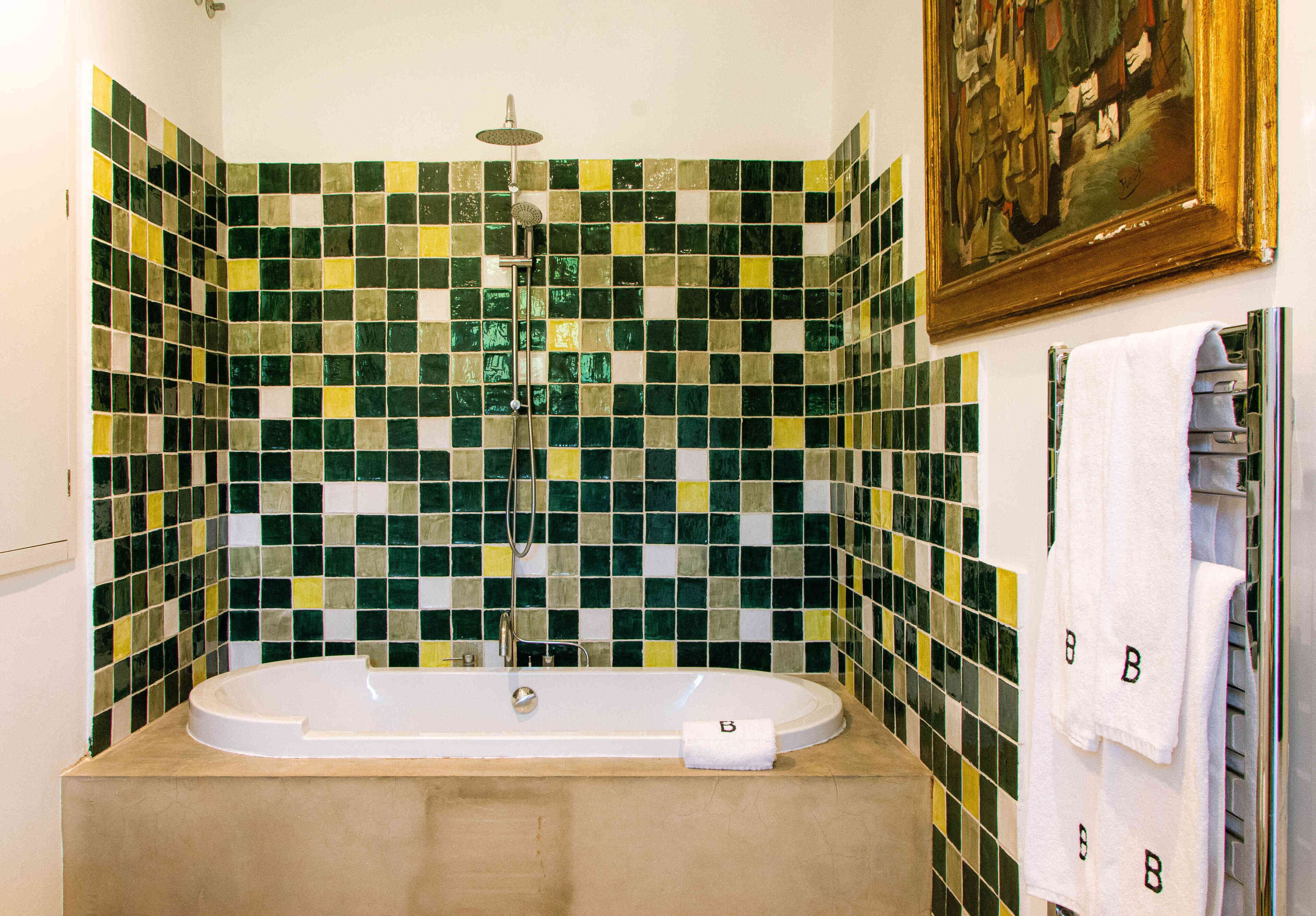 Ein Badezimmer mit einer Badewanne, einer Dusche und einer gefliesten Wand.