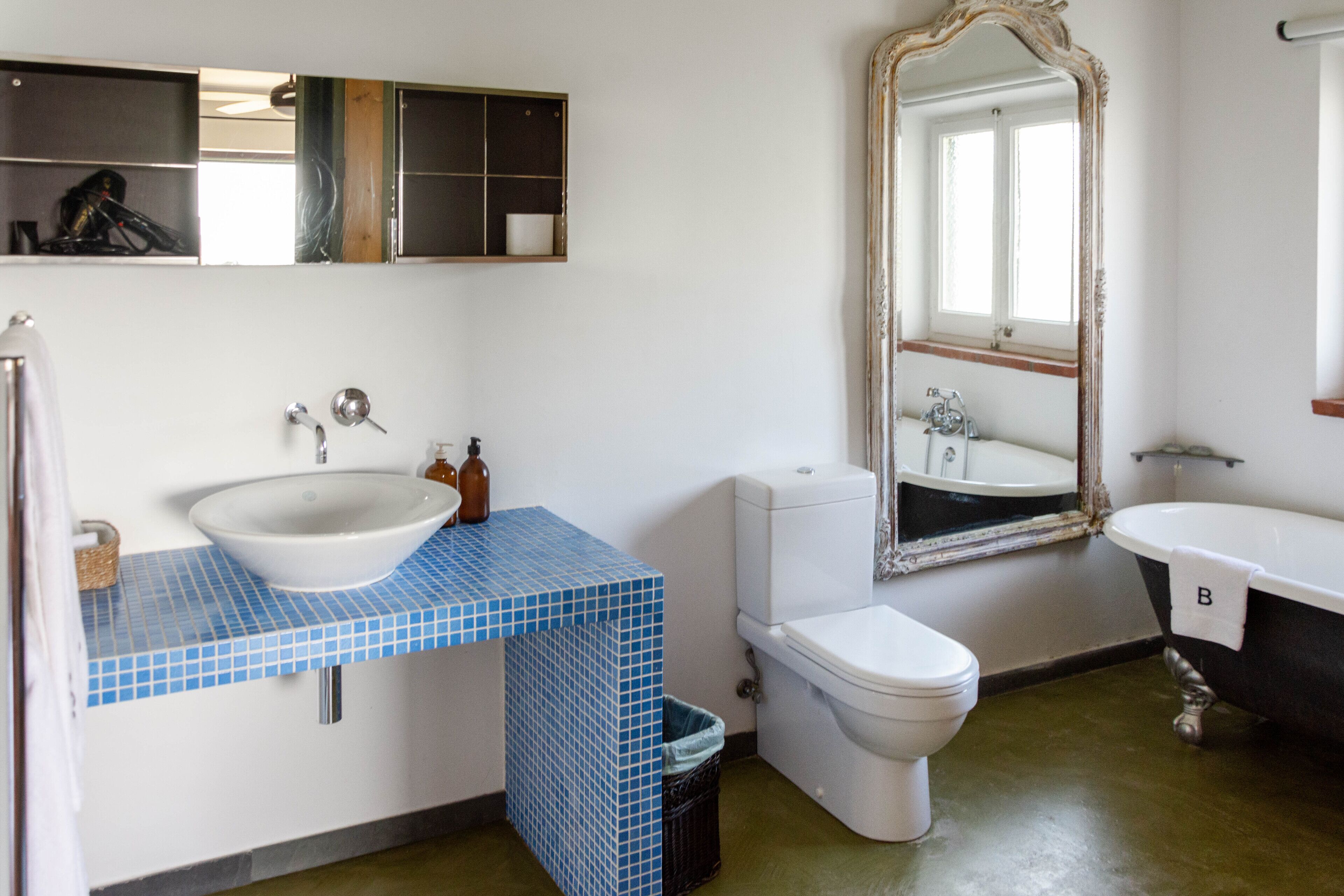 A bathroom with a white sink, a toilet, a bathtub, and a mirror.