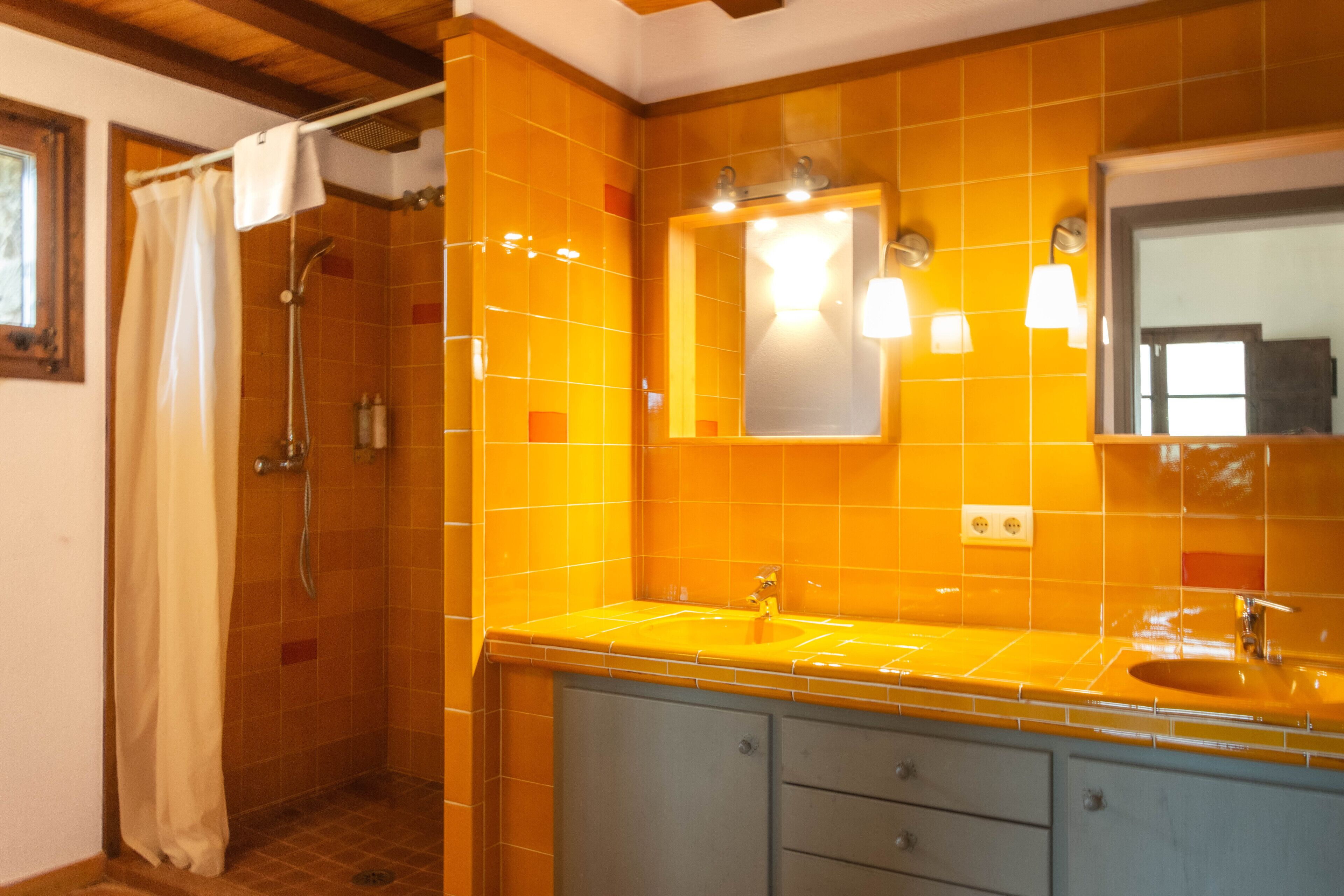 A bathroom with a shower, a sink, and a mirror.